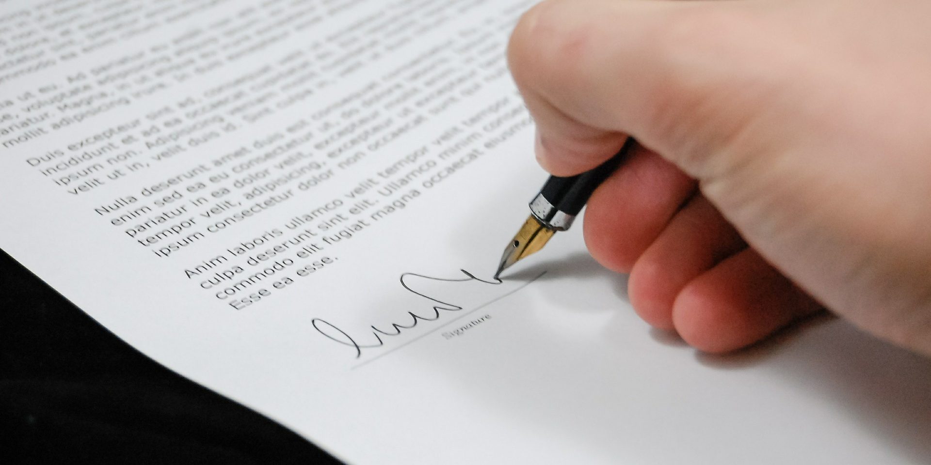 picture of a man putting his signature on a contract