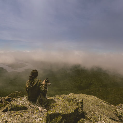 picture of girl with her dog on top of a mountain