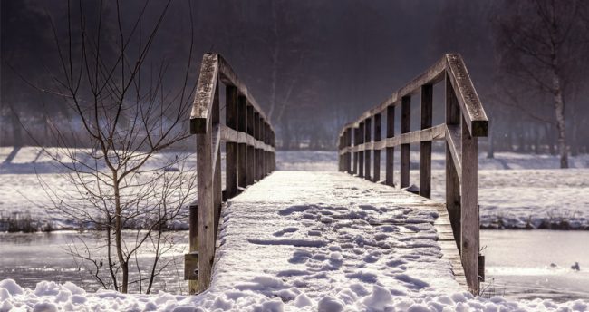 Snowy wooden bridge over mountain stream for the CFO Taskforce on SDGs - blog post