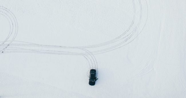 picture from above of a car driving in the snow visualizing the blog article about the interview with sebastian gschwill