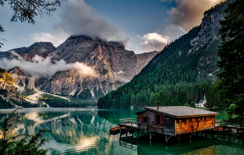 picture of a cabin in a lake in front of mountains